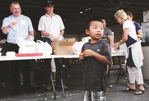 A child waits in line at the annual Thanksgiving in the Park gathering, where residents of the farm worker community of Immokalee are provided with a free meal, Immokalee, Florida. Now in its 36th year, the event is sponsored by area faith based organisations.