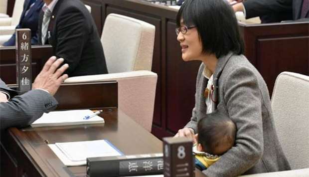 Kumamoto City assembly member Yuka Ogata holds her seven-month-old baby during a session in Kumamoto, Japan.