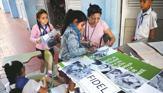 Cuban primary school students prepare a collage with images of late Cuban leader Fidel Castro in Havana yesterday.
