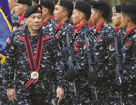 President Rodrigo Duterte, wearing a military uniform, reviews scout ranger troops upon his arrival during the 67th founding anniversary of the First Scout Ranger regiment in San Miguel town, Bulacan province, north of Manila, yesterday.