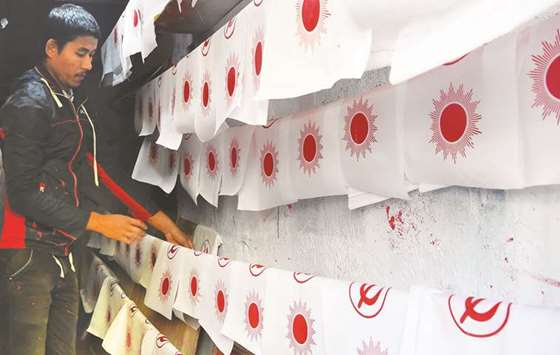 A worker making political party flags for the Communist Party of Nepal (Unified Marxistu2013Leninist) in Kathmandu.