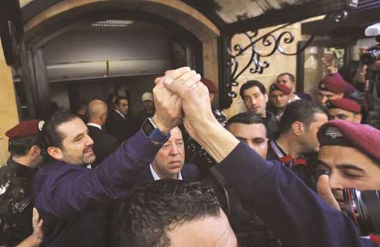 Lebanese Prime Minister Saad Hariri greets his supporters upon his arrival at his home in Beirut.