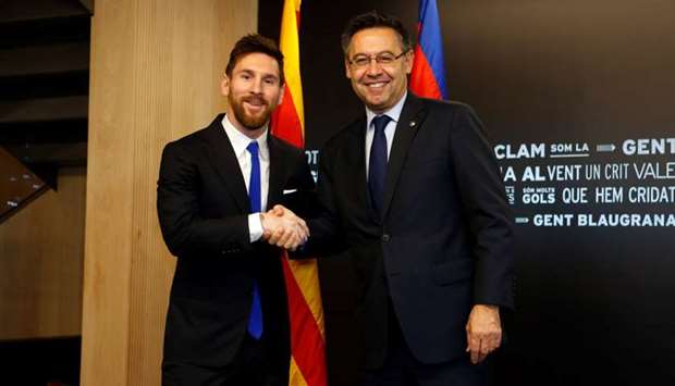 Barcelona's Argentine superstar Lionel Messi poses with FC Barcelona president Josep Maria Bartomeu during the signing of his new contract in Barcelona, Spain.