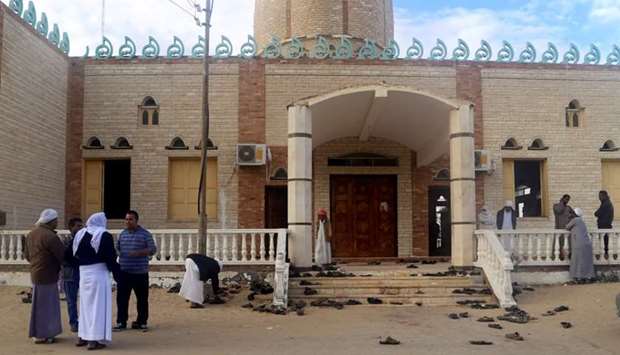 People stand outside Al Rawdah mosque, where a bomb exploded, in Bir Al-Abed, Egypt