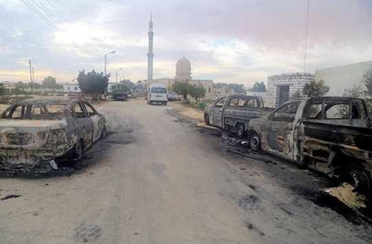 Damaged vehicles are seen after a bomb exploded at Al Rawdah mosque in Bir Al-Abed, Egypt yesterday.