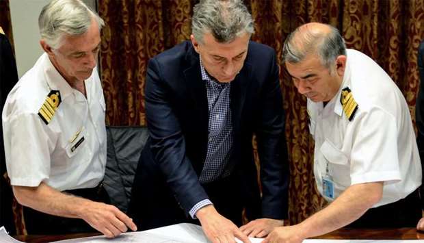 Argentina's Presidency shows President Mauricio Macri (C) and members of the Argentine Navy looking at the plan of missing submarine ARA San Juan