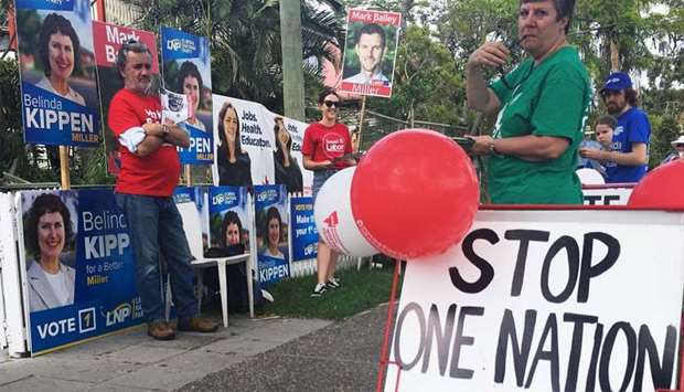 Voters stand by a ,stop One Nation - vote Labor, sign in Graceville, near Brisbane