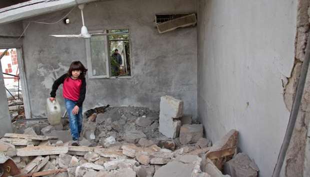 A Syrian child runs through the rubble following a reported shelling by Syrian government forces in the town of Mesraba in the eastern Ghouta region, a rebel stronghold east of the capital Damascus.
