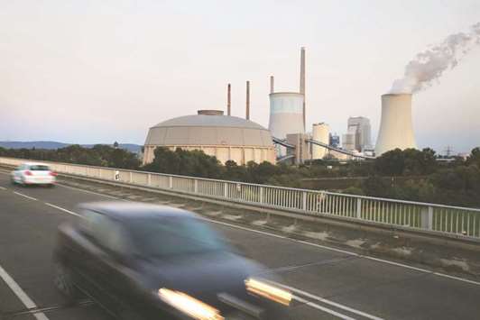 Automobiles travel as a cooling tower emits vapour at the coal-powered power plant operated by Uniper in Grosskrotzenburg, Germany (file). Coal power supplied about 40% of all Germanyu2019s electricity last year but about a third of its carbon dioxide pollution.
