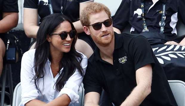 Britain's Prince Harry (R) sits with  actress Meghan Markle