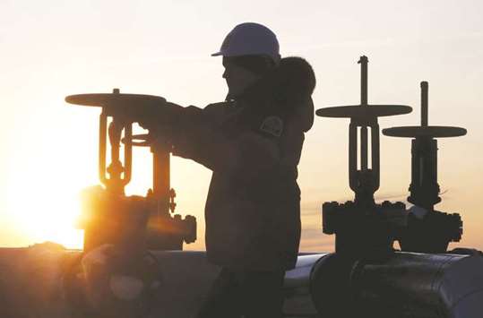 A worker checks the valve of a pipe at the Lukoil owned Imilorskoye oilfield near Kogalym, Russia (file). While Russia and Opec have crafted the outline of a deal to continue their curbs for nine months beyond the current end-March expiry, Moscow still has concerns that supporting oil prices above $60 a barrel will help US shale rivals.