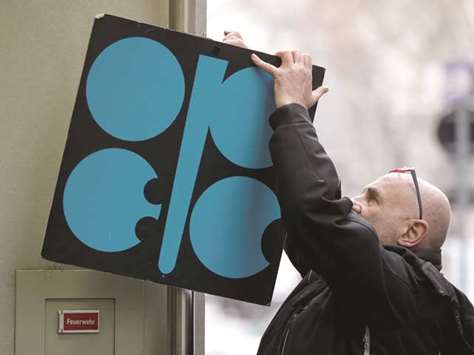 A man fixes the Opec logo next to its headquarters entrance before a meeting of oil ministers in Vienna yesterday. The higher the price, the more this will help shale oil  producers in the US, which are outside the agreement, ramp up production and take market share.