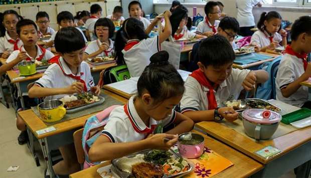 Students eat their lunch during the lunch break at their school in Shanghai