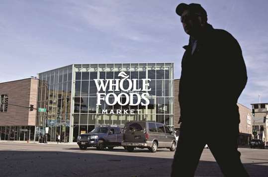 A pedestrian passes in front of the Lakeview Whole Foods Market store in Chicago. The Commerce Department said consumer spending, which accounts for more than two-thirds of US economic activity, rose 0.3% last month after surging 0.9% in September.