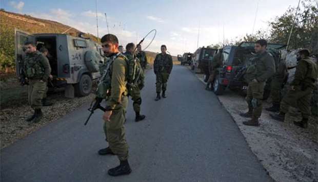 Israeli soldiers close a road near the border with Syria in the Israeli-annexed Golan Heights, after heavy clashes in the Syrian side on Friday.
