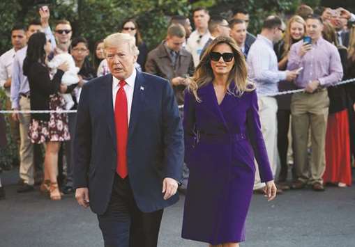 US President Donald Trump and First Lady Melania Trump walk towards reporters before departing from the South Lawn of the White House yesterday in Washington, DC, embarking on a 11-day tour of Asia.