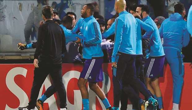 Teammates try to calm down Marseilleu2019s defender Patrice Evra (left) as he tries to kick a supporter before the start of the UEFA Europa League match against Vitoria SC at the D. Afonso Henriques stadium in Guimaraes on Thursday. (AFP)