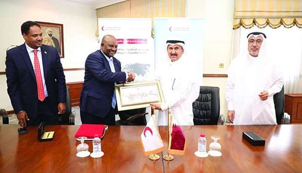 Ethiopian ambassador Mesganu Arga Moach and Issa Mohamed al-Ishaq, Director of Communication QRCS, shake hands after signing the MoU.