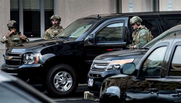 US Marshals wait to company an armored vehicle with Mustafa al-Imam as it leaves after a hearing at the US District Court in Washington