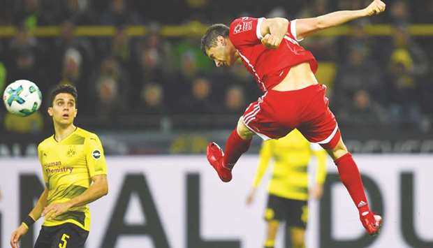 Bayern Munichu2019s Robert Lewandowski (right) heads the ball during the Bundesliga match against Borussia Dortmund in Dortmund, Germany, yesterday. (AFP)