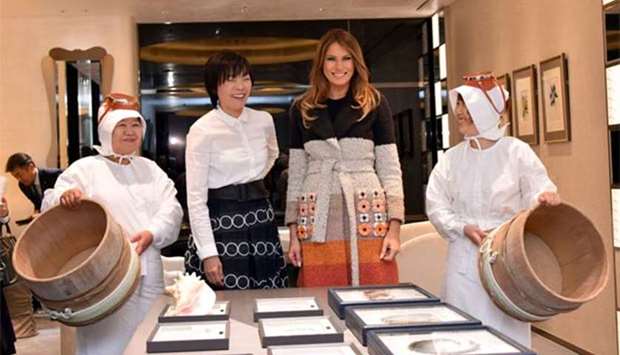 US First Lady Melania Trump poses with Japan's First Lady Akie Abe, alongside Ama divers, during their visit to the Mikimoto Pearl head shop in Tokyo's Ginza district on Sunday.