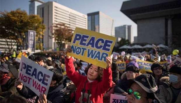 Demonstrators hold placards during a peace rally in Seoul on Sunday.