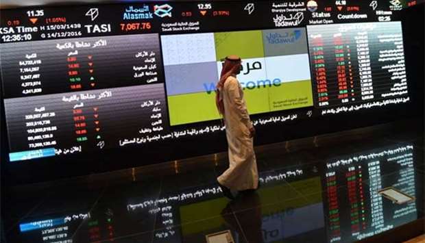 A Saudi investor walking past the stock exchange monitors at the Saudi Stock Exchange in Riyadh in this file photo. Shares in Kingdom Holding, owned by Prince Al-Waleed bin Talal, dived 9.9% on Sunday.