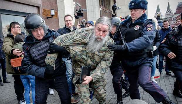 Russian riot police detain an opposition activist during a protest rally in central Moscow