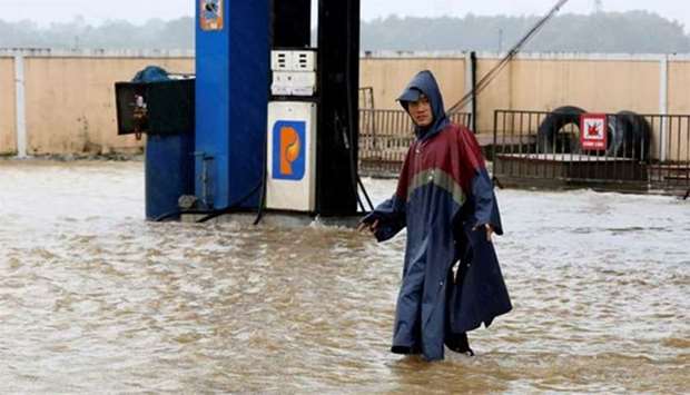 A man walks along a flooded petrol station in Hue city, Vietnam after Typhoon Damrey hit on Sunday.
