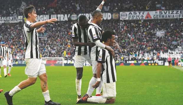 Juventusu2019 Juan Cuadrado (right) celebrates with teammates after scoring during the Italian Serie A football match against Benevento in Turin yesterday. (AFP)