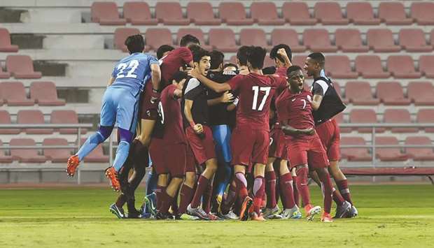Qatar players celebrate their win over Lebanon yesterday. At right, a piece of action from the match.