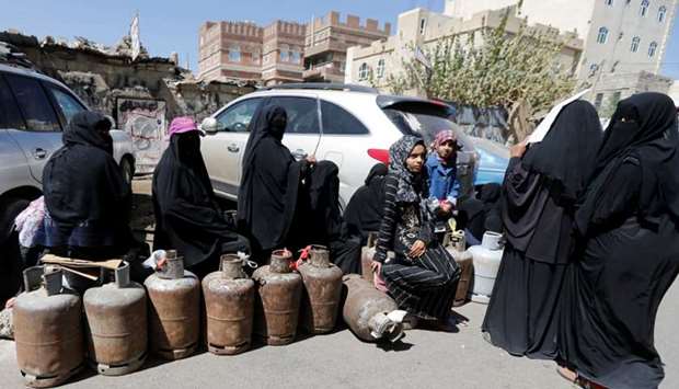 Women wait to fill up cooking gas cylinders outside a gas station amid supply shortage in Sanaa, Yemen