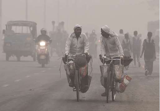 Commuters drive amid heavy smog in New Delhi yesterday.
