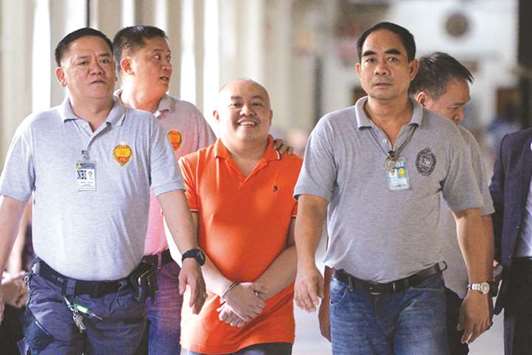 Philippine doctor Russell Salic is escorted by National Bureau of Investigation (NBI) agents for a court hearing in Manila yesterday.