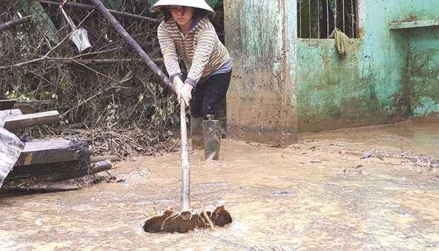 A woman clears mud in a village in Quang Nam yesterday after the area was flooded by rains brought by Typhoon Damrey at the weekend.