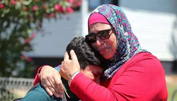 A woman hugs her son near where a vehicle crashed into a primary school classroom in the Sydney suburb of Greenacre on Tuesday.