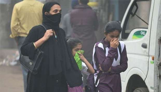 An Indian woman and children walk amid heavy smog in New Delhi on Wednesday.