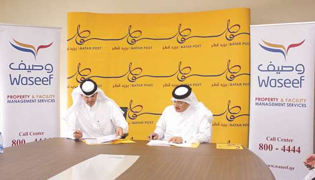 Waseefu2019s Hamad Rashed al-Kuwari and Qatar Postu2019s Faleh al-Naemi signing the MoU.