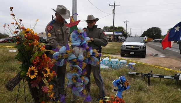 State troopers check a memorial outside the First Baptist Church, which was the scene of the mass shooting that killed 26 people in Sutherland Springs, Texas.
