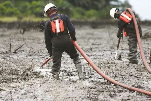 Workers flush the crude oil polluted creek shoreline at the Bodo clean-up site in Rivers State, Nigeria.