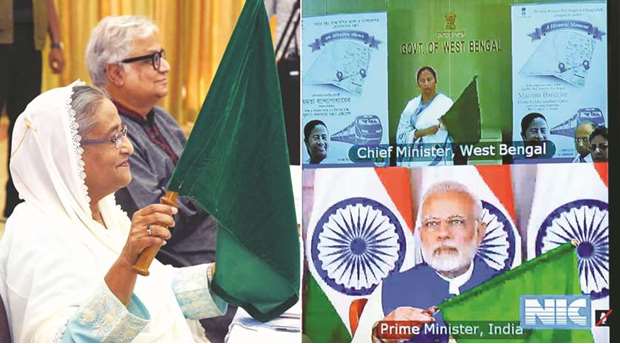 Prime Minister Sheikh Hasina waves the Bangladeshi flag along with Indian Prime Minister Narendra Modi and Indiau2019s West Bengal state Chief Minister Mamata Banerjee, during a videoconference yesterday.