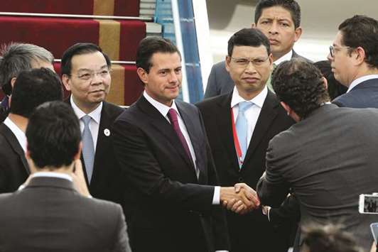 Mexicou2019s President Enrique Pena Nieto (centre) arrives at the Apec CEO summit in Danang, Vietnam, yesterday. Asia-Pacific ministers struggled yesterday to agree on a joint statement on free trade, a rare tussle over a normally routine document that highlights how Donald Trumpu2019s protectionist u201cAmerica Firstu201d stance is knotting up global trade relations.