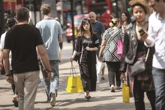 Shoppers walk along the Oxford Street in London. The European Commission has cut its 2017 prediction for the UK and sees growth cooling to just 1.1% in 2019, which would be the worst performance since the recession of 2009.