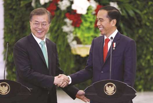 South Korean President Moon Jae-in (left) and Indonesian President Joko Widodo shake hands at the end of their joint statement to the media at the presidential palace in Bogor, south of Jakarta, yesterday. Indonesia and South Korea signed a memorandum of understanding on a light rail transit (LRT) system in Jakarta, part of a series of pacts reported to be worth up to $1.9bn.
