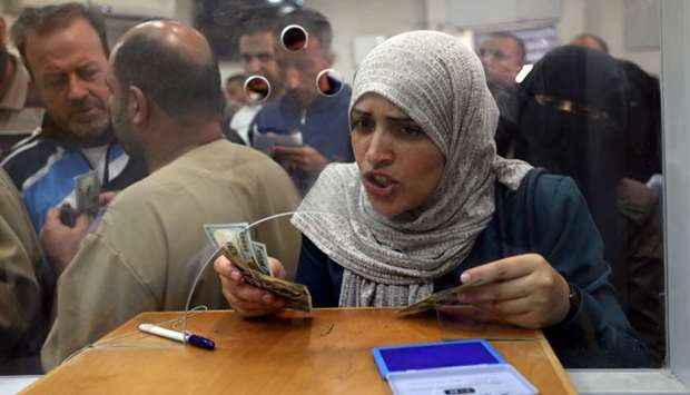 A Palestinian Hamas-hired employee receives her salary, in the southern Gaza Strip