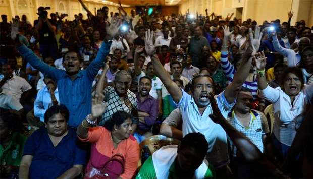 Supporters of ousted Sri Lanka's Prime Minister Ranil Wickremesinghe shout slogans as they gather at the prime minister's official residence in Colombo