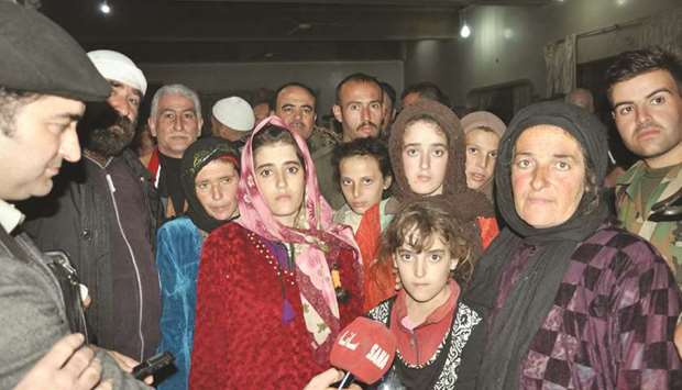 A handout picture released by the official Syrian Arab News Agency (SANA) yesterday shows a group of Druze women and children, abducted in July from Sweida by the Islamic State group, pose for a picture.