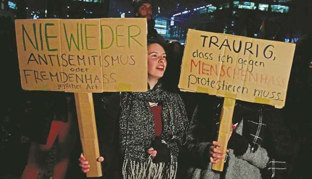 Protesters hold up placards which read u2018Never Again  anti-Semitismu2019 (left) and u2018Sad that I have to protest against hateu2019, as supporters of the far-right u2018We For Germanyu2019 movement stage their rally in Berlin.