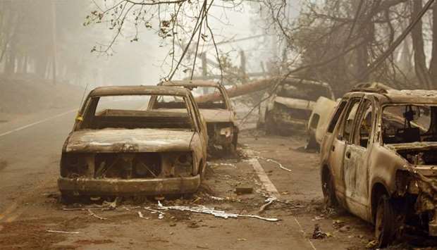 Burnt out vehicles are seen on the side of the road in Paradise, California