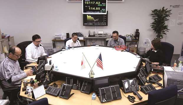 Currency traders work in the dealing room of a foreign exchange brokerage in Tokyo (file). The yen reached its weakest since early October on Friday, before recovering as concern over Chinau2019s economy fuelled declines in global equities and eroded risk appetite.